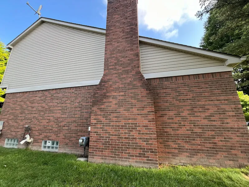 Completed light-colored siding and trim above a brick exterior