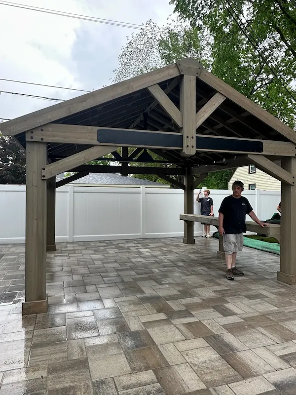 Timber pavilion built over a patterned paver patio