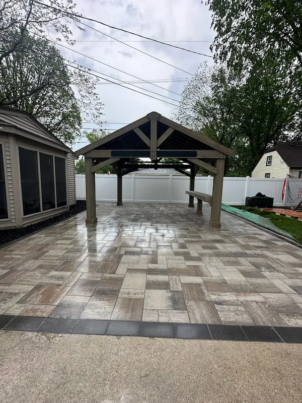 Completed backyard pavilion at the end of a paver patio